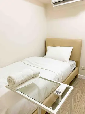 a small room with a bed with a glass table at 2BR Loft at Fort Victoria Condominium BGC in Manila