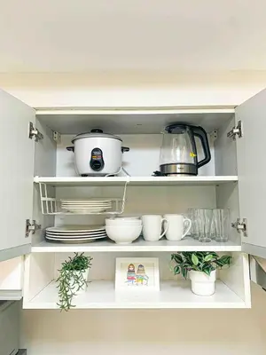a kitchen shelf with dishes and pots and pans at 2BR Loft at Fort Victoria Condominium BGC in Manila