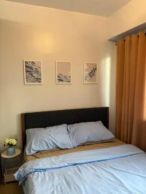 a bed in a bedroom with pictures on the wall at Azul Paradise in Manila