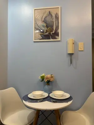 a table with two plates and a vase with flowers on it at Azul Paradise in Manila