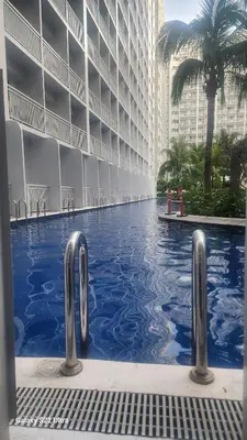 a swimming pool in front of a tall building at Azul Paradise in Manila