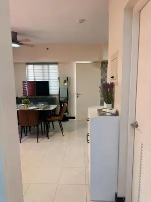 a kitchen and living room with a table and a refrigerator at torre de manila taft luneta park view in Manila