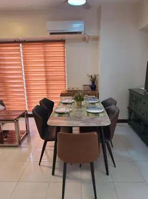 a dining room with a table and some chairs at torre de manila taft luneta park view in Manila