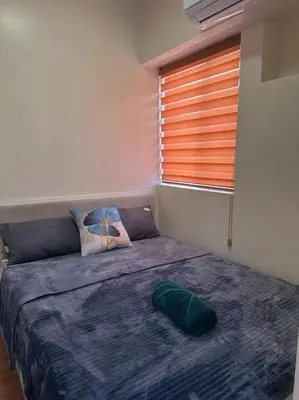a bedroom with a large bed with a window at torre de manila taft luneta park view in Manila