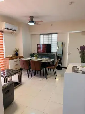 a kitchen and living room with a table and chairs at torre de manila taft luneta park view in Manila