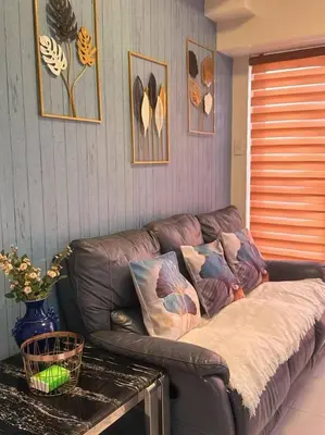 a brown leather couch in a living room with a table at Family Rooms with View in Manila