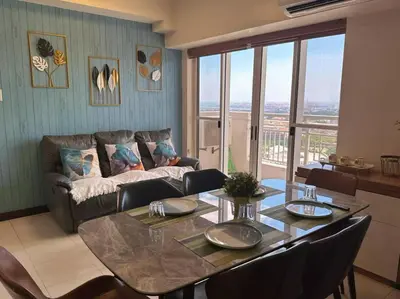 a living room with a table and a couch at Family Rooms with View in Manila