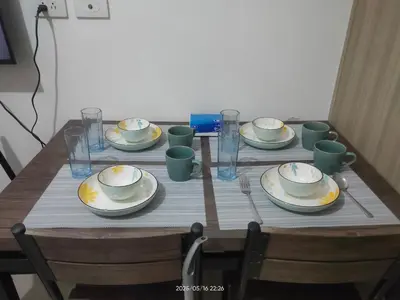 a wooden table with plates and cups on it at Shore Residences in Manila