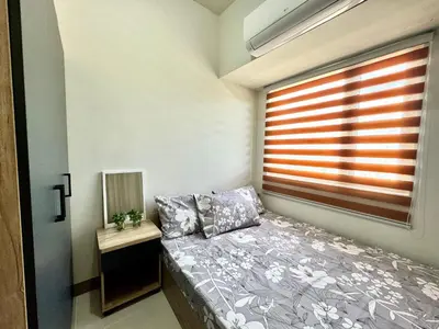 a small bedroom with a bed and a window at Coast Residences Ivy in Manila