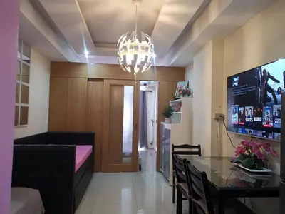 a dining room with a table and a chandelier at 352B Shell Residences Barkada Room in Manila