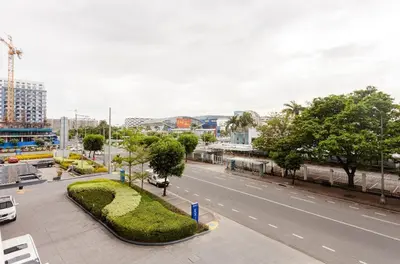 an empty street in a city with buildings and trees at 352B Shell Residences Barkada Room in Manila