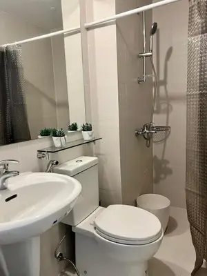 a white bathroom with a toilet and a sink at SM Bicutan Boracay Tower in Manila