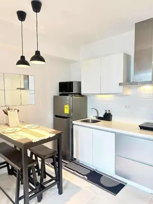 a kitchen with a table and a stainless steel refrigerator at SM Bicutan Boracay Tower in Manila