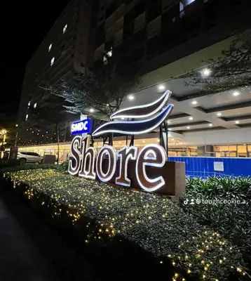 a large sign for a store at night at Legit Staycation walking distance to Mall of Asia located in Shore1 and 2 Residences in Manila