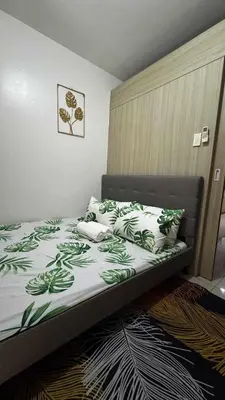 a bedroom with a bed with green and white sheets and pillows at Manila Staycation walking distance to Mall of Asia and near Manila Airport in Manila