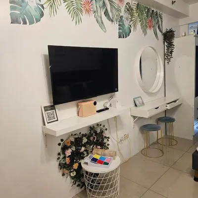 a living room with a tv on a wall at Cathys Haven Urban Escape in MOA in Manila