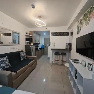 a living room with a couch and a kitchen at Cathys Haven Urban Escape in MOA in Manila
