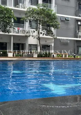 a large blue swimming pool in front of a building at Modern Comfort at MOA Shore 3 in Manila
