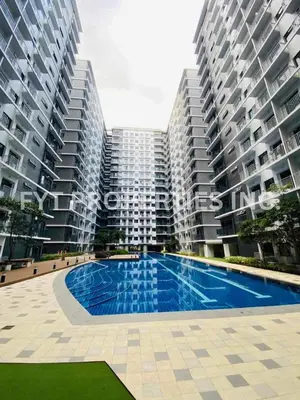 a swimming pool in front of two large buildings at Modern Comfort at MOA Shore 3 in Manila