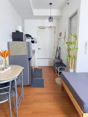 a living room with a table and a refrigerator at You Have VIN Here in Manila