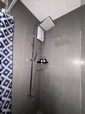a shower in a bathroom with a glass shower stall at Solace Haven in Manila