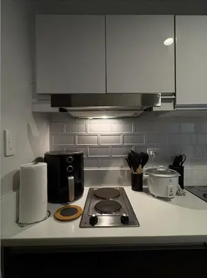a kitchen counter with a stove and a microwave at Solace Haven in Manila