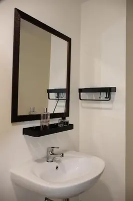 a bathroom with a white sink and a mirror at Kasara Urban Resort Elly's Pad with balcony in Manila