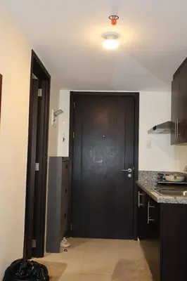 a kitchen with a black door and a black cabinet at Kasara Urban Resort Elly's Pad with balcony in Manila