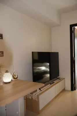 a living room with a flat screen tv on a wall at Kasara Urban Resort Elly's Pad with balcony in Manila