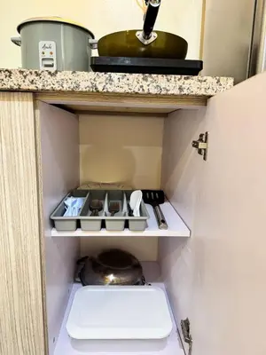 a kitchen with a shelf with a pot and pans at Danny's Haven Ortigas in Manila