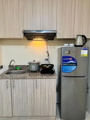a kitchen with a sink and a refrigerator at Danny's Haven Ortigas in Manila