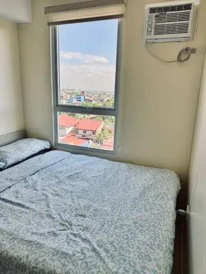 a bedroom with a bed and a window at Danny's Haven Ortigas in Manila