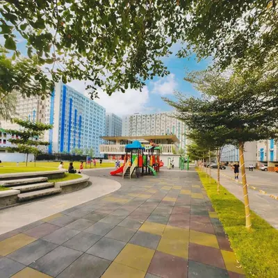 a park in a city with a playground and buildings at Danny's Haven Ortigas in Manila