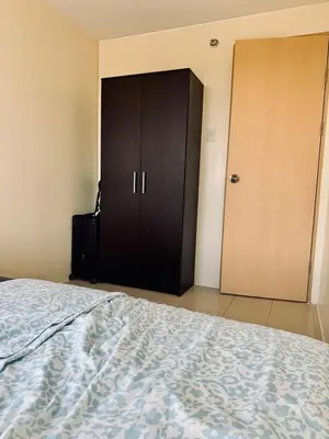 a bedroom with a bed and a closet and a door at Danny's Haven Ortigas in Manila