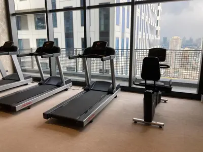 a gym with several tread machines in a large window at Luxury Condo at Century Spire in Central Makati in Manila