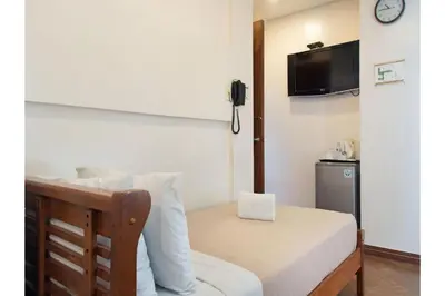 a hotel room with a bed with a phone on the wall at Belvilla Airport Stays Near Makati Manila Formerly Avitel Hotel in Manila