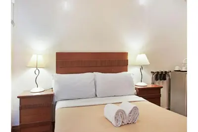 a bedroom with a bed with two towels on it at Belvilla Airport Stays Near Makati Manila Formerly Avitel Hotel in Manila
