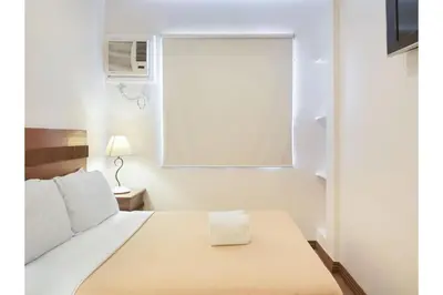 a small bedroom with a bed and a window at Belvilla Airport Stays Near Makati Manila Formerly Avitel Hotel in Manila