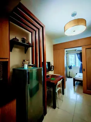 a kitchen with a refrigerator and a table in it at Darren Staycation in Manila