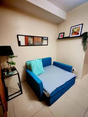 a blue couch in a living room with a table at Darren Staycation in Manila