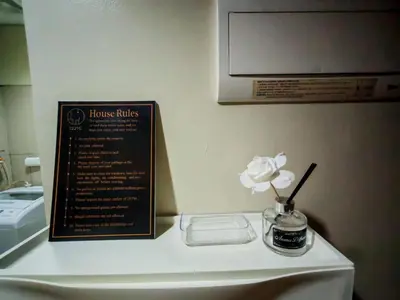 a flower in a vase on a table with a sign at Darren Staycation in Manila
