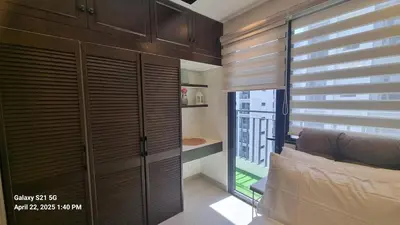 a bedroom with a bed and a window with blinds at Cozy new studio walk to Mall of Asia with balcony in Sampong