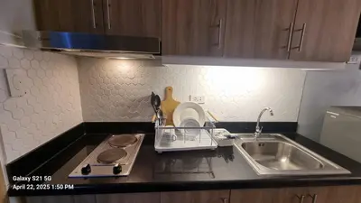 a kitchen counter top with a sink and a sink at Cozy new studio walk to Mall of Asia with balcony in Sampong