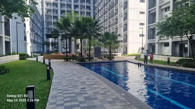 a swimming pool in a city with tall buildings at Cozy new studio walk to Mall of Asia with balcony in Sampong