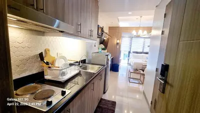 a kitchen with a sink and a counter top at Cozy new studio walk to Mall of Asia with balcony in Sampong