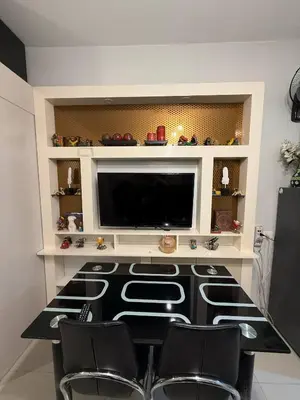 a room with a table and chairs and a flat screen tv at Zion Staycation at Sea Residences in Manila