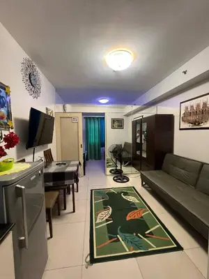 a living room with a couch and a table at Zion Staycation at Sea Residences in Manila