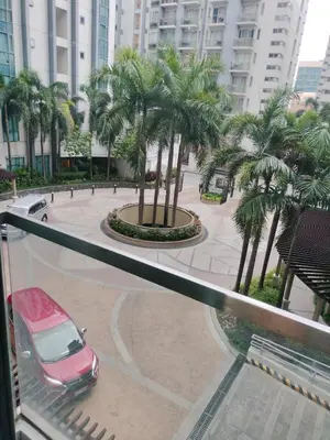 a red car parked on a street with palm trees at Rqui Condotel at Newport Pasay City in Manila