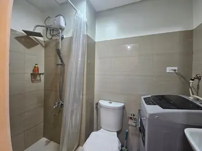 a bathroom with a shower and a toilet and a sink at The Executive Suites at Shore 2 Residences in Manila