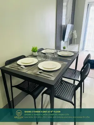 a black table with chairs and plates on it at Shore 3 Residences Spacious & Spotless 1BR unit near airport MOA SMX in Manila
